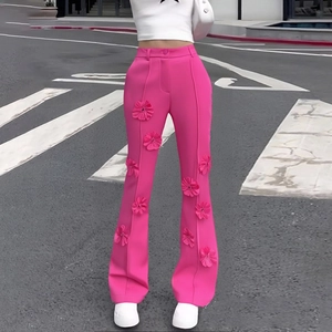 Dettaglio di fiori 3D su pantaloni a zampa a vita alta rosa shocking all'aperto