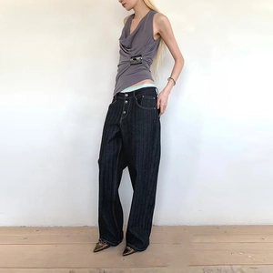 Detail of a gray sleeveless top with pleated neckline and denim wide-leg jeans outfit