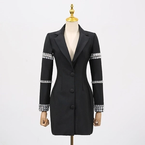 Détail des ornements en strass sur les manches d'une robe blazer noire ajustée