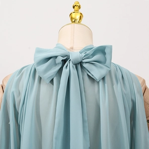 Detail of light blue sleeveless blouse with tie-up bow neckline and pleated chiffon fabric