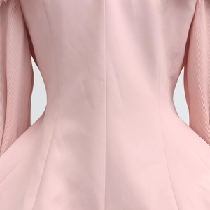Detail of pink blouse with pleated sleeve design and tailored waist stitching