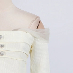 Detail of square neck tweed top with mesh straps and floral rhinestone buttons