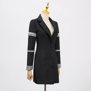 Détail des ornements en strass sur les manches d'une robe blazer noire ajustée
