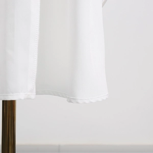Détail de l'ourlet de la jupe blanche avec coutures nettes et fente latérale élégante