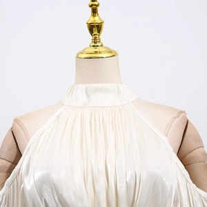 Detail of elegant off-white halter neck blouse with vertical pleats and satin luster