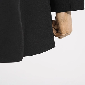 Detailed close-up of premium black blazer fabric with a smooth and crisp texture