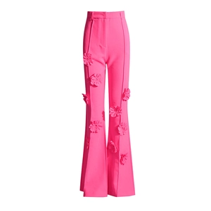 Dettaglio dei fiori 3D sui pantaloni a zampa a vita alta rosa shocking di tendenza