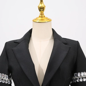 Détail du revers et des franges de strass luxueuses sur les manches de la robe noire