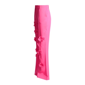 Dettaglio di applicazioni floreali 3D sulla cucitura laterale dei pantaloni magenta a vita alta