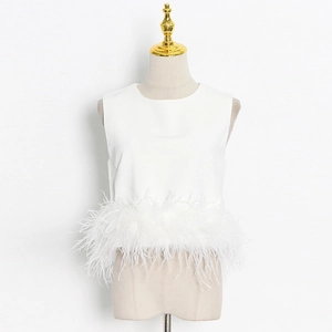 Detail shot of white sleeveless top featuring premium ostrich feather trim hem