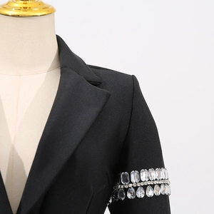 Détails des ornements de luxe en strass sur la manche d'une robe blazer noire élégante