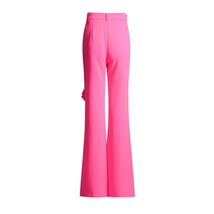 Dettaglio dei pantaloni svasati rosa a vita alta con fiore 3D e design a pieghe sul retro