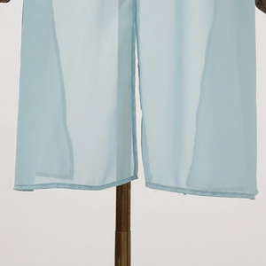 Detail view of light blue chiffon fabric hem with sheer texture and fine stitching