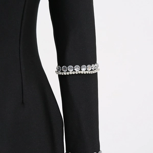 Gros plan de la manche de robe noire élégante avec détails en cristal et strass brillants