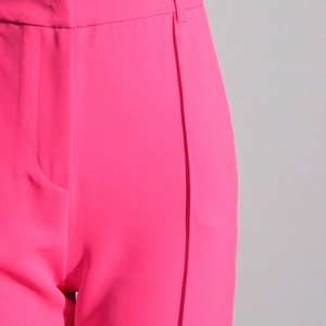 Dettaglio dei pantaloni a vita alta rosa con cuciture rifinite e trama del tessuto