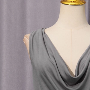 Detail of grey draped neck sleeveless top showing pleated fabric texture on a mannequin