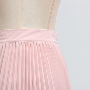 Detail of light pink pleated chiffon skirt featuring precise vertical pleats and neat stitching