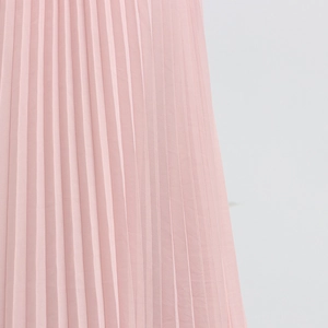 Detail of light pink pleated chiffon fabric showing vertical texture and fine craftsmanship