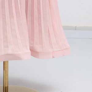 Detail view of light pink pleated chiffon skirt fabric with high-density vertical accordion pleats