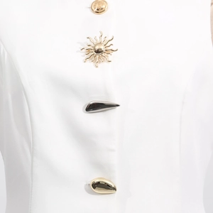 Detail of artistic gold and black decorative buttons on a white sleeveless top