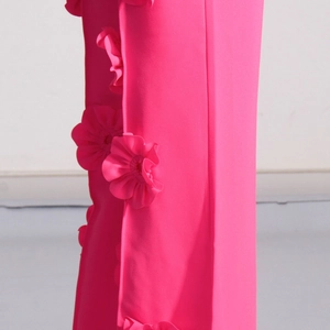 Dettaglio dei pantaloni svasati rosa con applicazioni floreali 3D fatte a mano sul lato