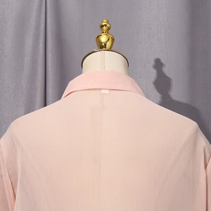 Detail of light pink peach shirt collar and vertical texture on flowing fabric