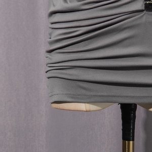 Detailed view of grey pleated fabric with elastic knitted texture and fine stitching