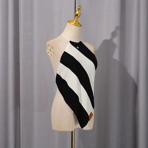 Detail of black and white striped knitted halter top with logo embroidery and leather tag