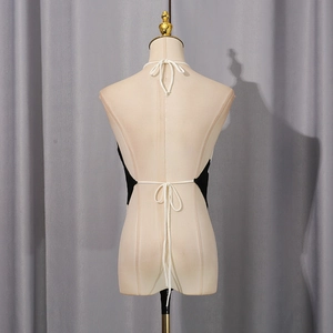 Detail of the knit halter top featuring elegant white lace-up ties on a backless design