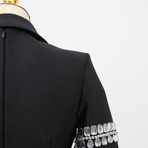 Vue détaillée d'une robe blazer noire avec des franges en strass et une texture élégante