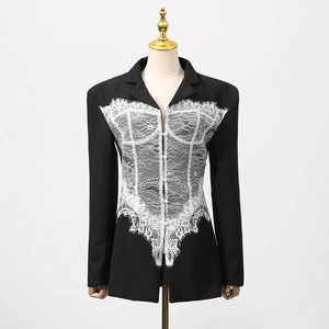 Detail of elegant black blazer featuring intricate white lace patchwork on the front