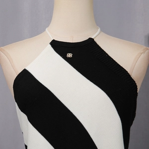 Detail of a halter knit top featuring black and white diagonal stripes and metal logo