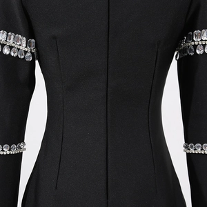 Détail d'ornements luxueux en strass sur la manche d'une robe bandage noire