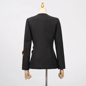 Detail view of women's black blazer with red floral 3D appliqués on the sleeves