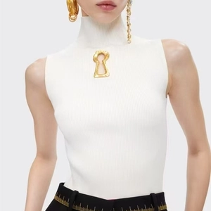 Détail d'un haut en tricot blanc sans manches avec décoration métallique en trou de serrure