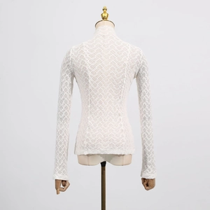 Detail view of white lace texture and geometric hollow mesh on slim-fit long sleeve top