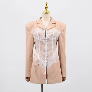 Detail of lace corset stitching on apricot blazer with peak lapels and buttons