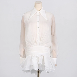 Detailed view of white long sleeve dress with large lapel and ruffled hemline