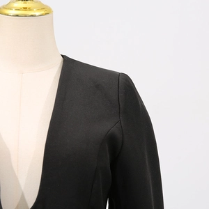 Detail of premium black blazer showing shoulder stitching and textured fabric finish