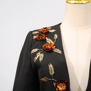 Detail of elegant black blazer featuring intricate floral embroidery and copper sequins