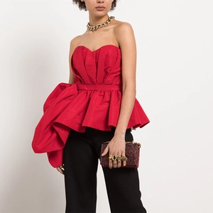 Detail of red strapless top with dramatic sculptural ruffles and golden chain necklace