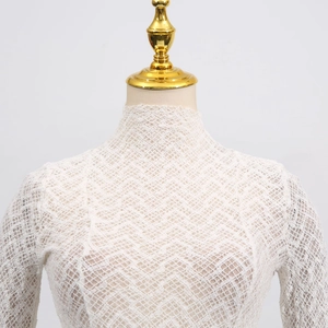 Detailed view of white lace texture and mock neck collar on a stylish slim knitted top