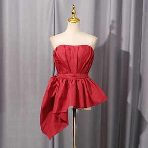 Close-up of shiny red satin strapless top with asymmetrical ruffles and draped waist detail