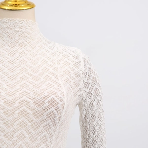 Detail shot of white crochet lace neckline with high collar and intricate floral textures