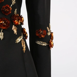 Detail of 3D orange sequin flowers and gold bead embroidery on black suit jacket