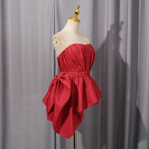 Detail of red strapless satin evening top with ruffles and a side bow decoration