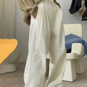 Detail showing the elegant high waist drape and wide leg cut of these cream casual trousers