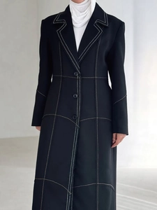 Slim long black trench coat with contrast stitching and classic lapels for women
