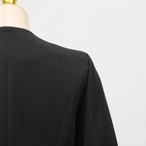 Detail shot of black blazer shoulder with pads and structured tailoring on mannequin