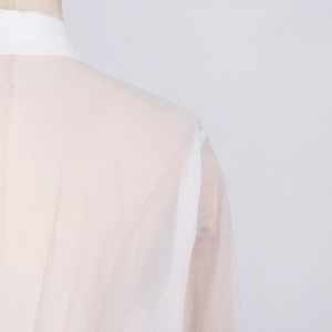 Detail of white sheer mesh shoulder with pleated fabric texture and lapel collar design